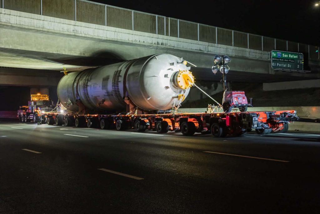 A big truck hauling a large object under a bridge | Heavy Haul | NessCampbell