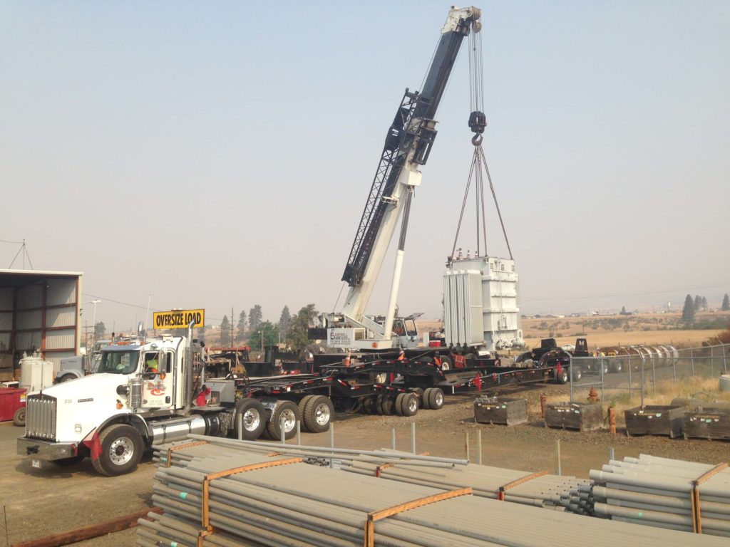 A crane hoists a big object onto a trailer | Crane Lift Planning | NessCampbell