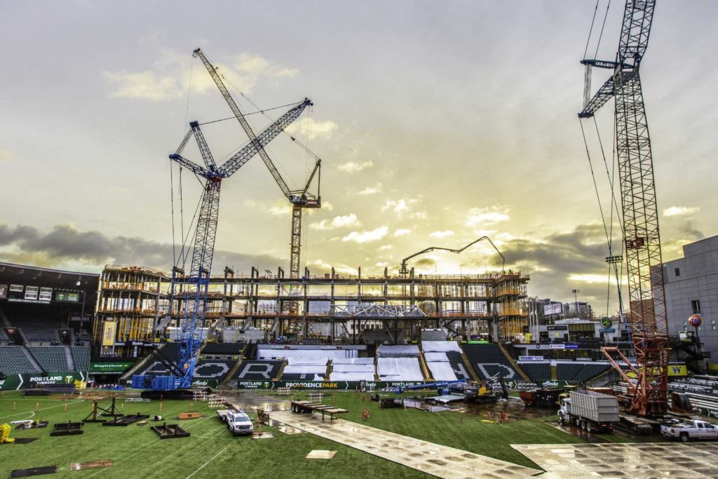 A stadium being built with cranes and a field in the background | Crane Services | NessCampbell