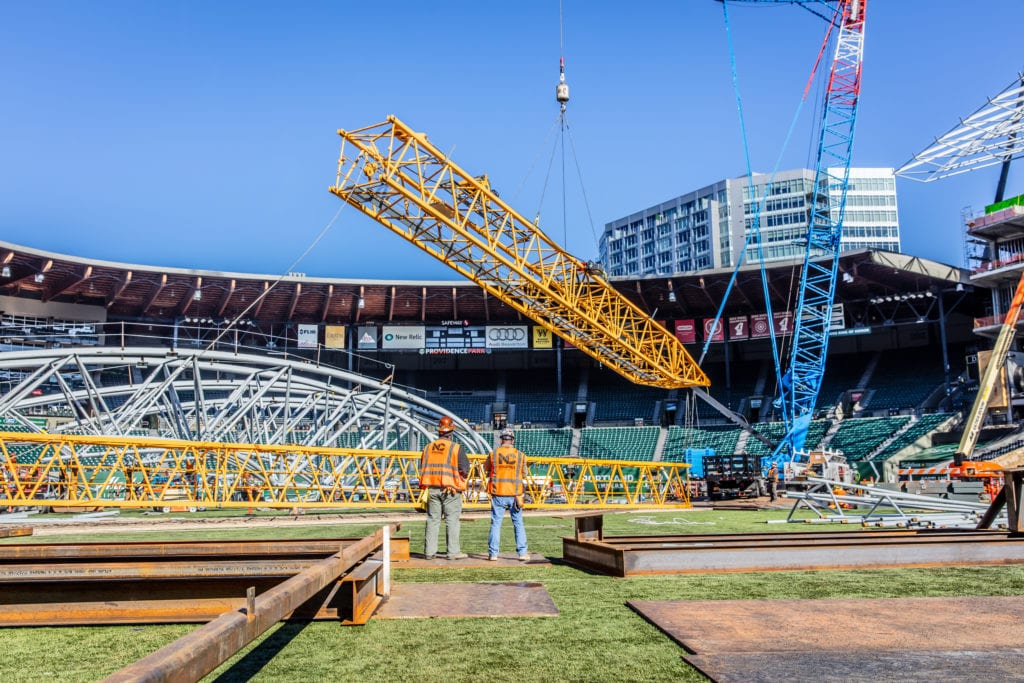 Construction workers building a stadium with the help of a crane | Crane Services | NessCampbell