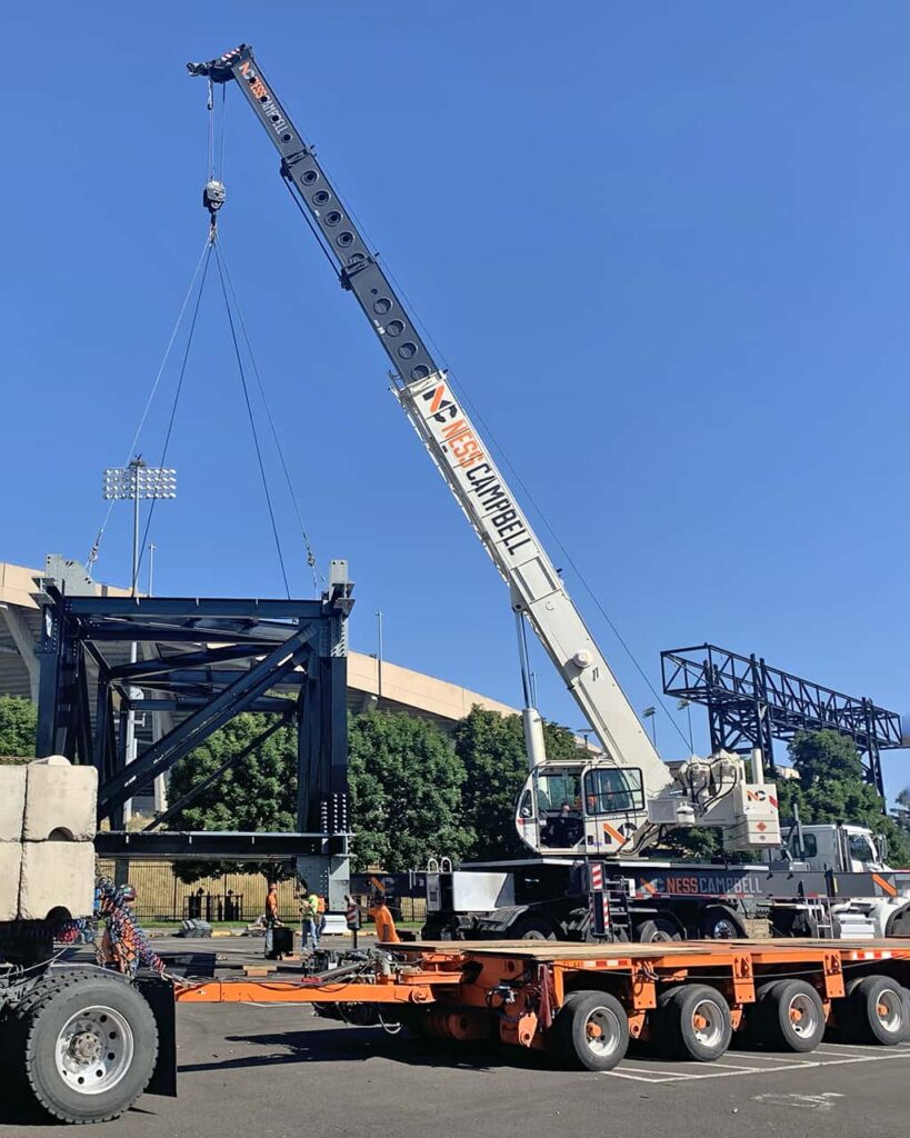 A crane hoists a trailer onto a big truck | Crane Rental Services | NessCampbell