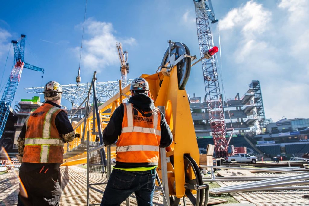 Construction workers working at a busy construction site | Lift Engineering Services | NessCampbell