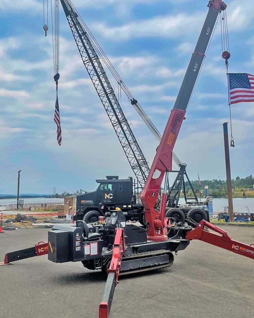 A crane hoists an American flag high in the air | Spider Crane Rental | NessCampbell